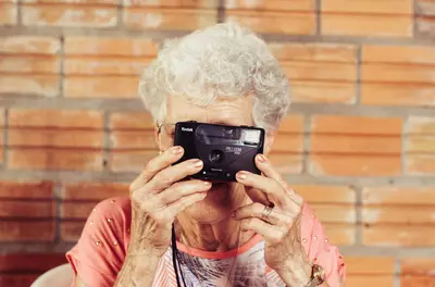 elderly woman taking a photo