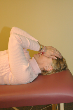 woman lying down with her hands over her eyes, doing self reiki
