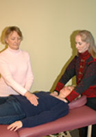 Two people practicing Reiki on a third
