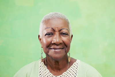 smiling elderly woman against a green background