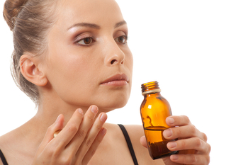 woman smelling a bottle of essential oils