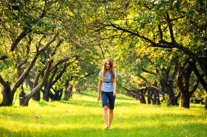 Woman walking through a beautiful green park. 