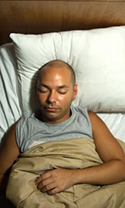 man sleeping peacefully in bed