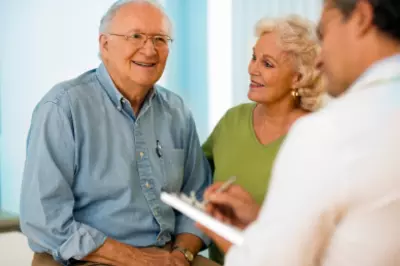 elderly couple speaking with a healthcare provider