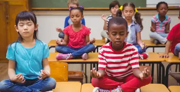 kids sitting cross legged in a class room