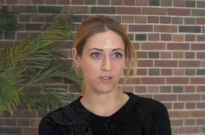 Kelly McGonigal sitting in front of a brick background