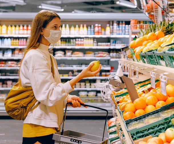 girl in supermarket holding lemon