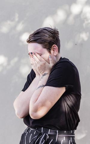 woman standing with her hands over her face