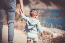 toddler walking by a pond