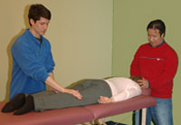 Two men practicing Reiki on woman