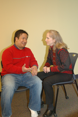 seated man talking to reiki practitioner