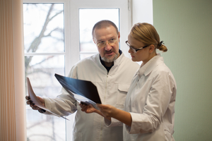 Two healthcare professionals examining a patient chart together