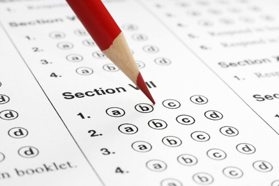 Red pencil filling in bubbles on standardized test