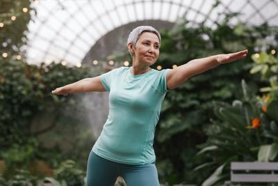 woman standing with arms outstretched in yoga pose