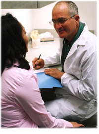 healthcare provider in white coat listening to patient and taking notes