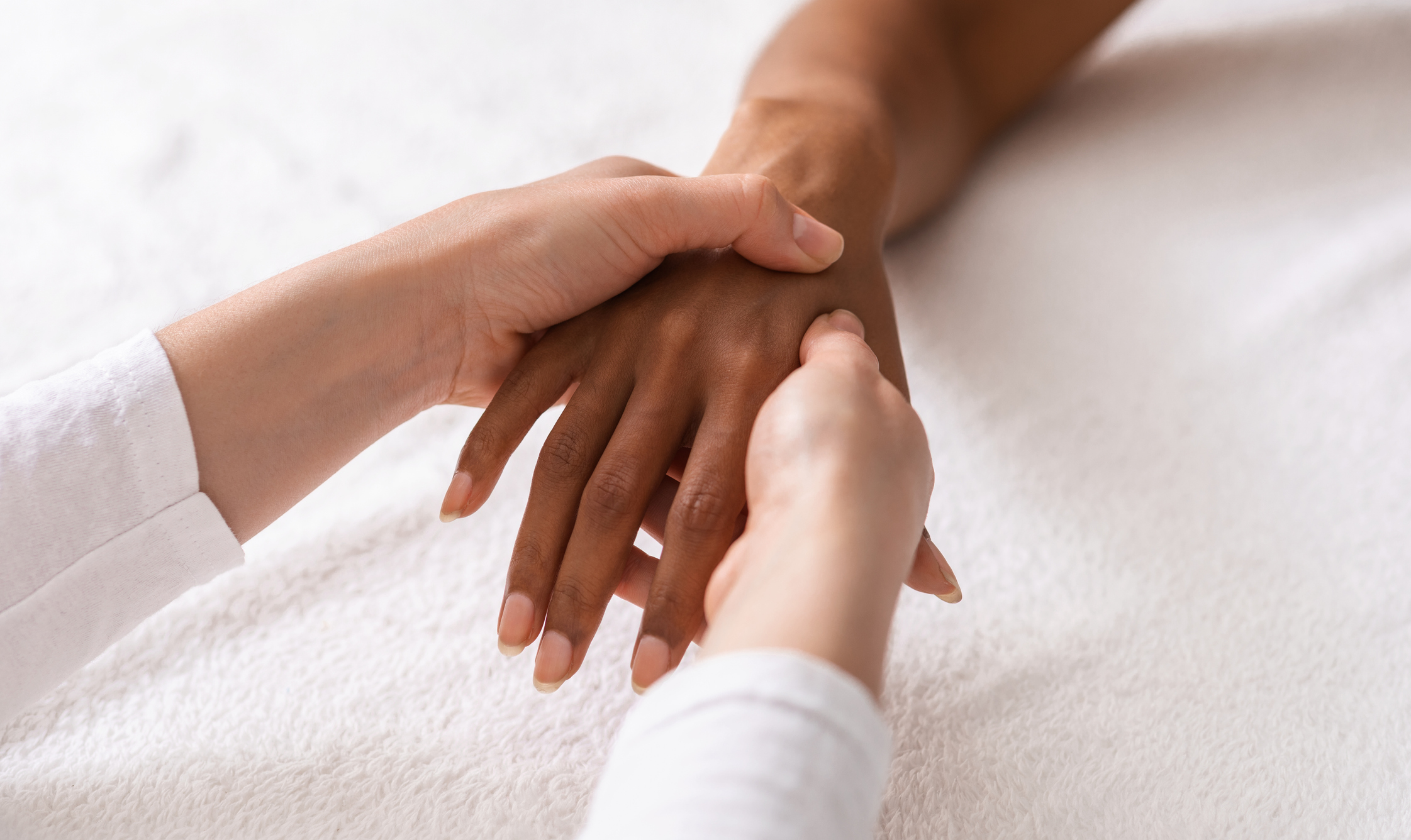 Person performing acupressure on a patient's hand