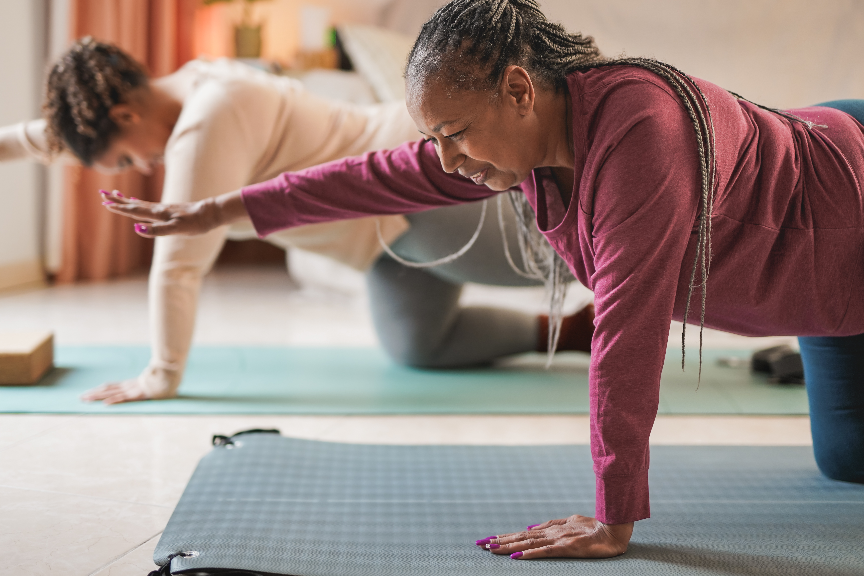 two people perform yoga poses