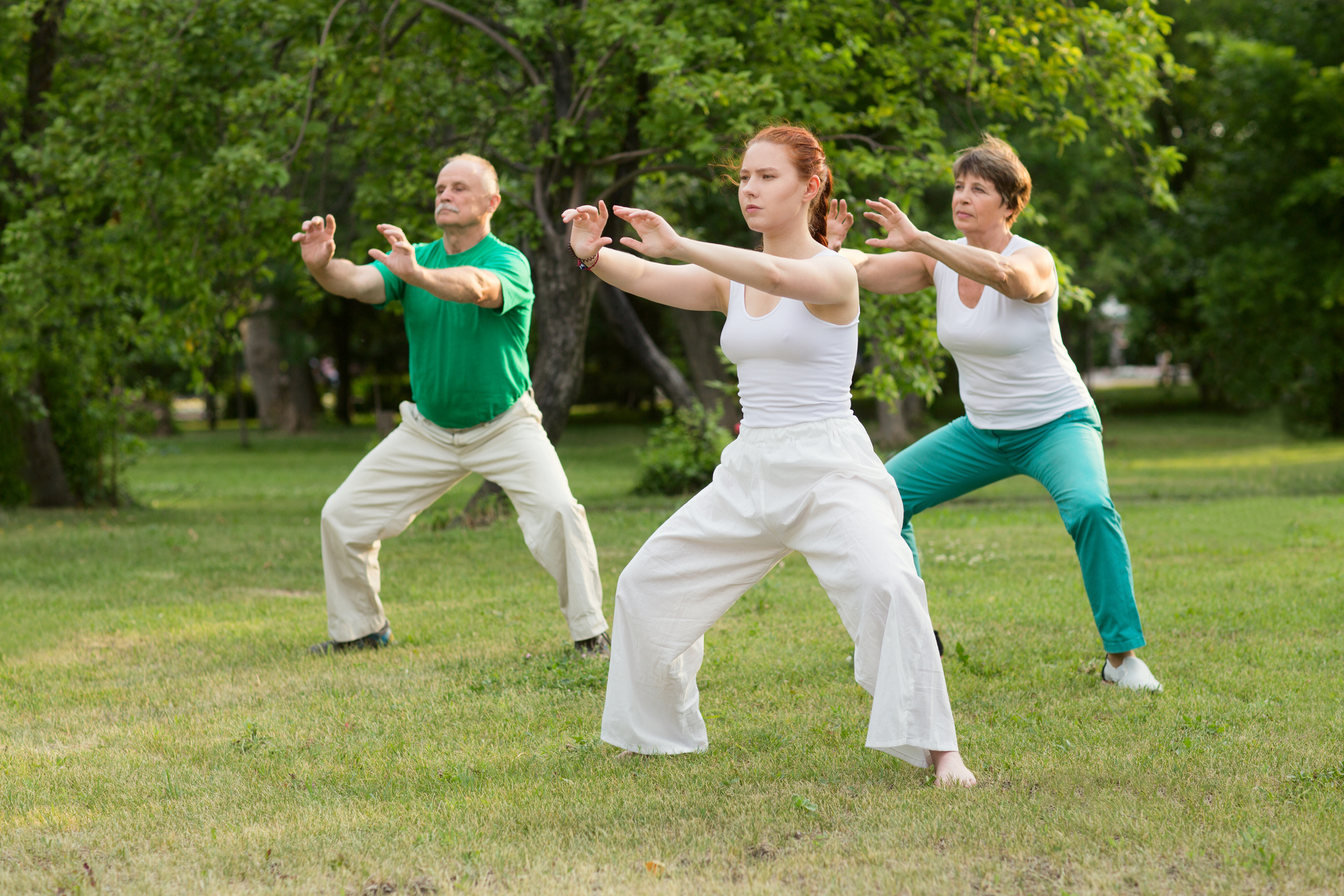 three people participate in tai chi