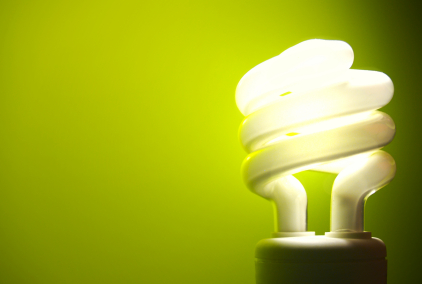 energy efficient light bulb lit in front of a green background