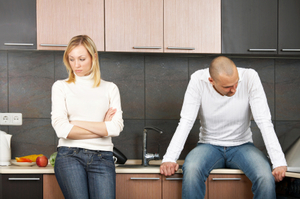 angry couple in their kitchen, not looking at one another