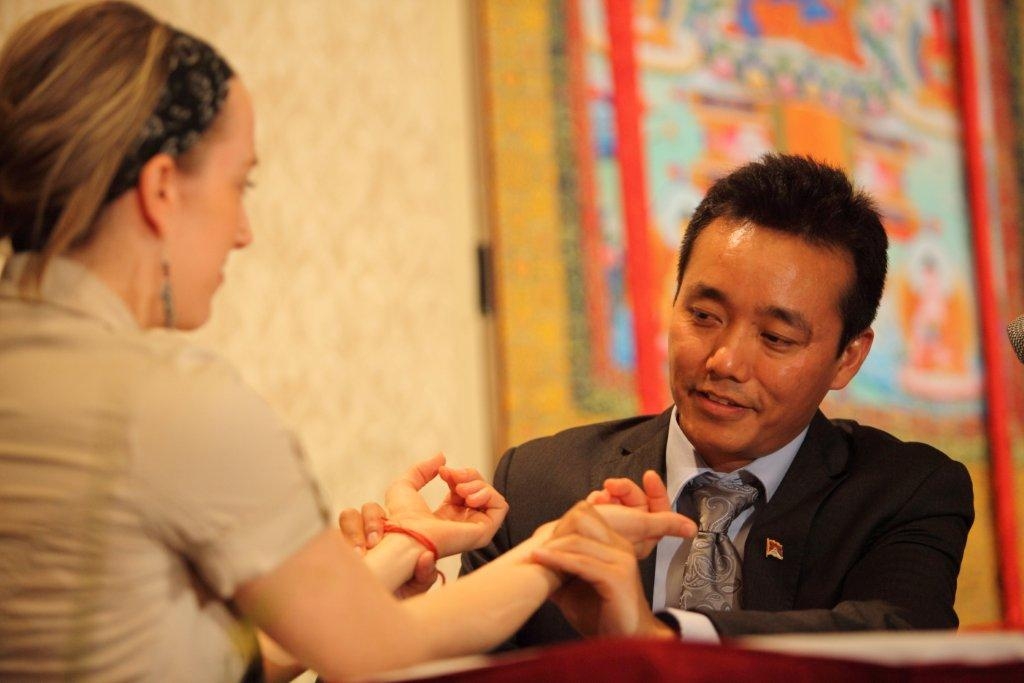 Tiben Medicine practitioner checking a patient's pulse.