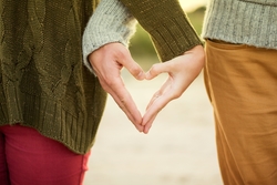 two people's hands joined together to form the shape of a heart