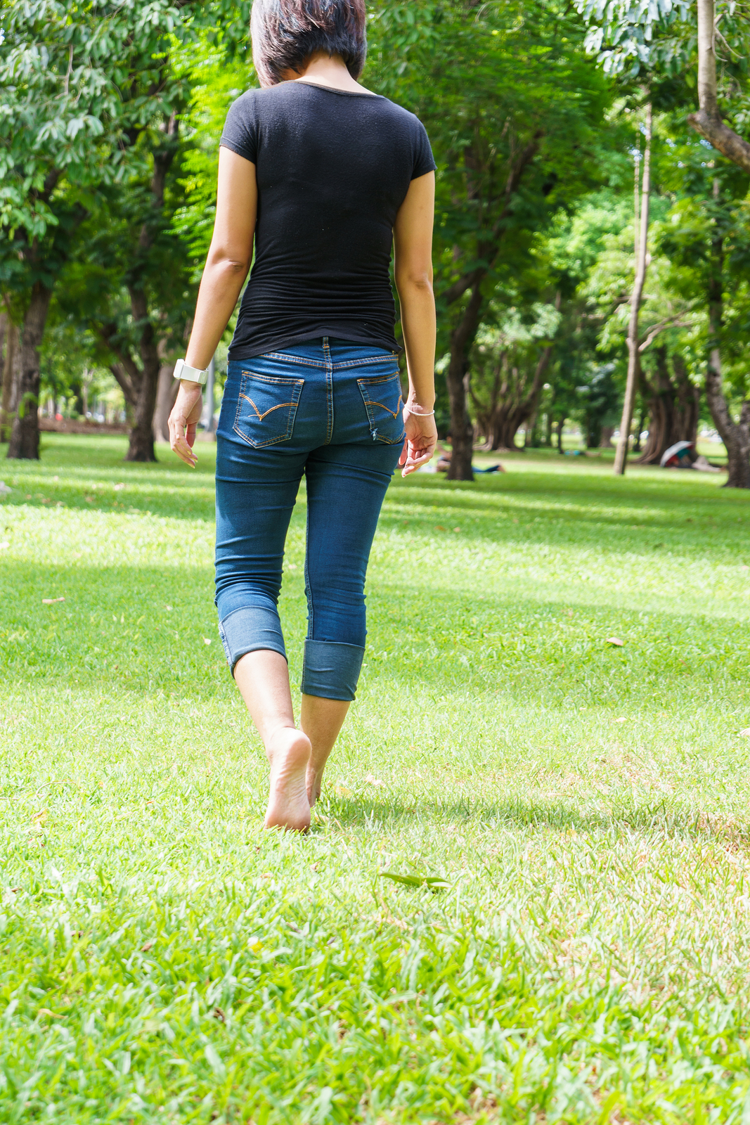 Woman walking park with bare feet.