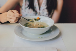 woman eating a bowl of broth soup