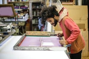 artist creating a print in his studio