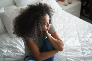 storyblocks-lonely-young-latina-woman-sitting-on-bed-depressed-hispanic-girl-at-home-looking-away-with-sad-expression_rLBhALBWm_1.jpg