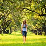 person walking through a grove of trees