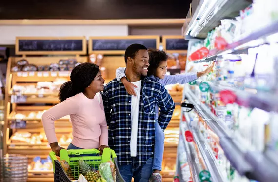 Portrait of happy black family with trolley shopping together at grocery store