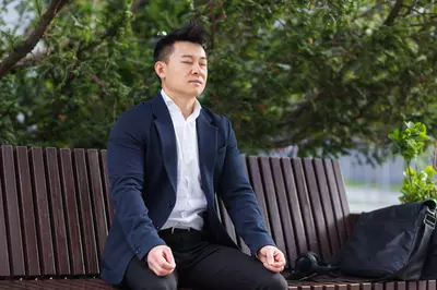person in suit breathing on a bench outside