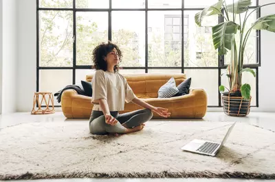 woman sitting in the lotus position in her living room