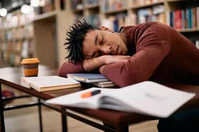 student sleeping in a library