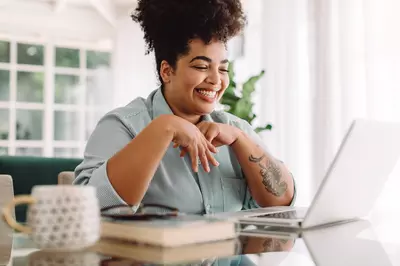 Woman video calling using laptop at home