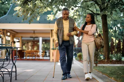 elderly man walking with his daughter