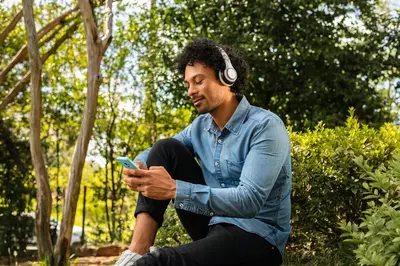 man sitting in the forest on his phone