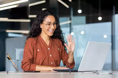 woman waving to someone on video chat