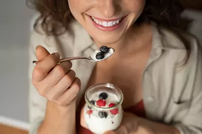 woman eating berries out of a cup