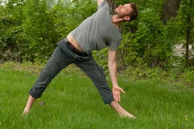 person doing yoga outside in a green park