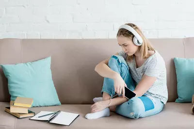 girl sitting on couch listening to music