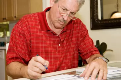 man looking stressed over paperwork