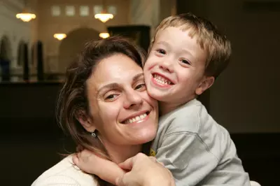 Woman smiles as she hugs her small child
