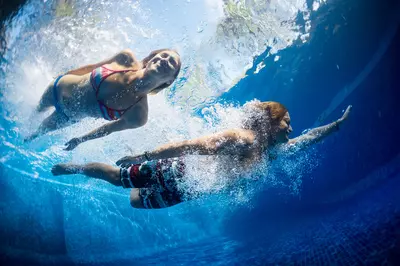 people swimming in a pool.