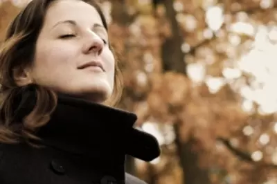 woman looking out into the distance with foliage in the background