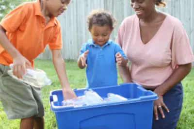 Three people, two adults and one child, recycling plastic 