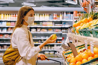 Person wearing a mask looking at produce.