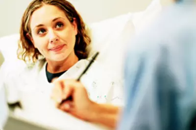 woman speaking to her doctor from a hospital bed