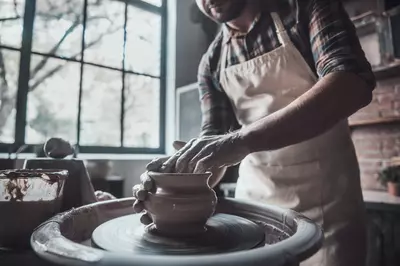 Man making a ceramic vase on a wheel